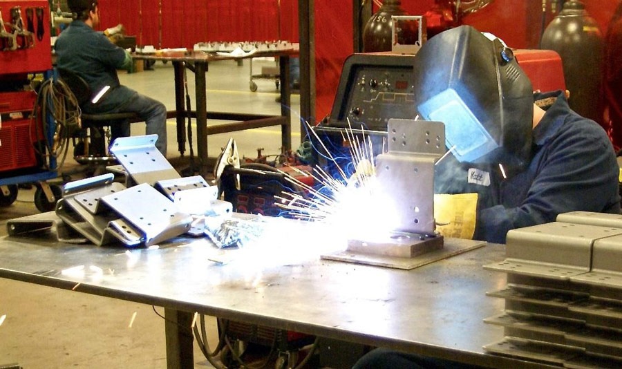 Certified weldors MIG-welding steel support plates.